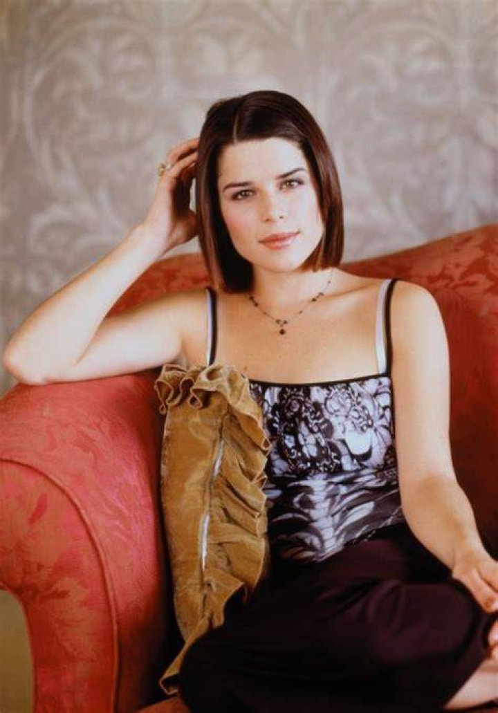 Neve Campbell stylish in floral blouse and black leather pants at